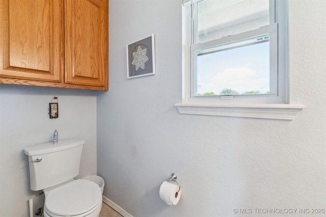 bathroom with toilet and baseboards