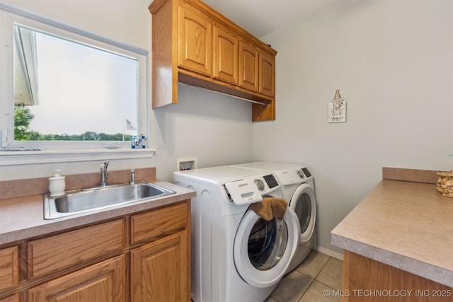 clothes washing area with washing machine and clothes dryer, cabinet space, light tile patterned flooring, and a sink