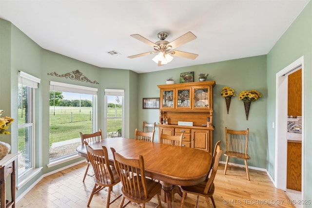 dining area featuring a wealth of natural light, light wood finished floors, and visible vents