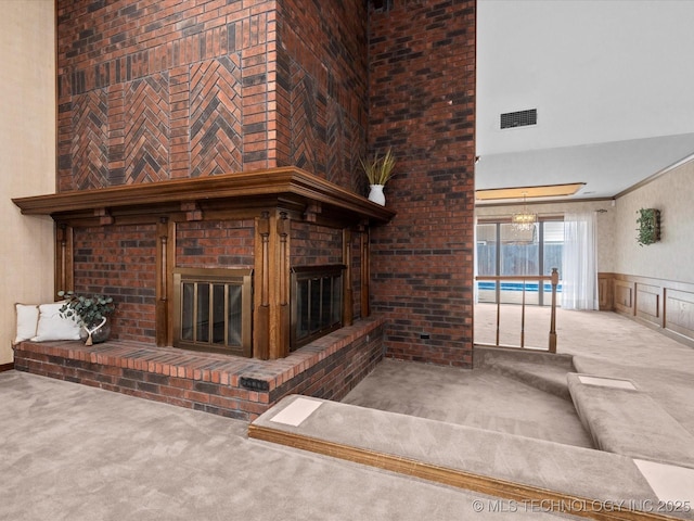 2600 Chapel Hill Rd, Bartlesville, OK 74006 - unfurnished living room featuring carpet floors, a fireplace, a towering ceiling, and wainscoting