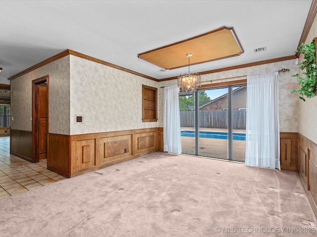 2600 Chapel Hill Rd, Bartlesville, OK 74006 - empty room with crown molding, a chandelier, a wainscoted wall, carpet flooring, and wallpapered walls