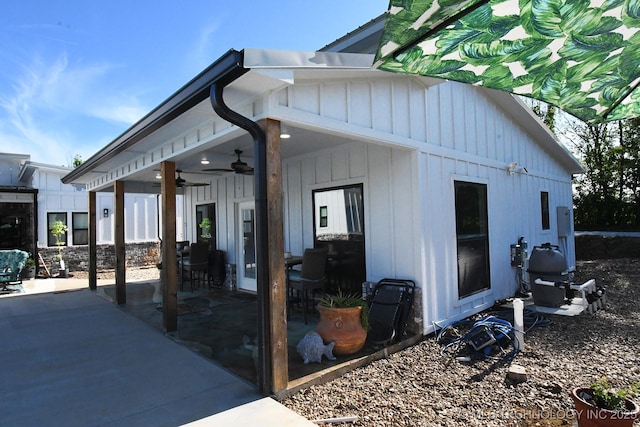 back of property featuring a ceiling fan, board and batten siding, and a patio