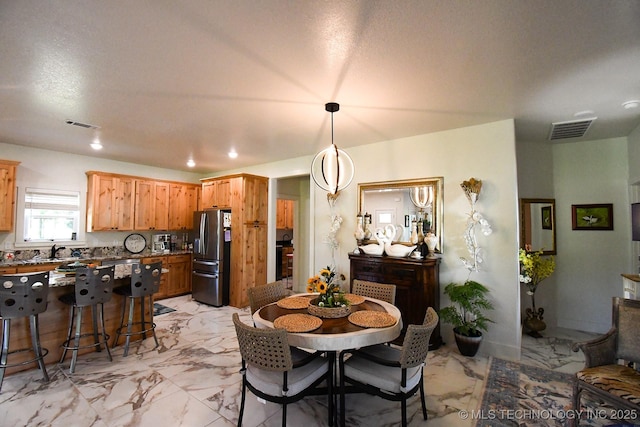 dining area featuring marble finish floor and visible vents