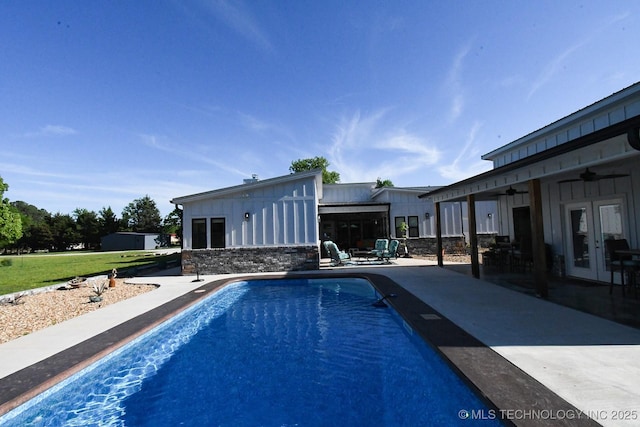 pool featuring a ceiling fan, a patio area, french doors, and a yard