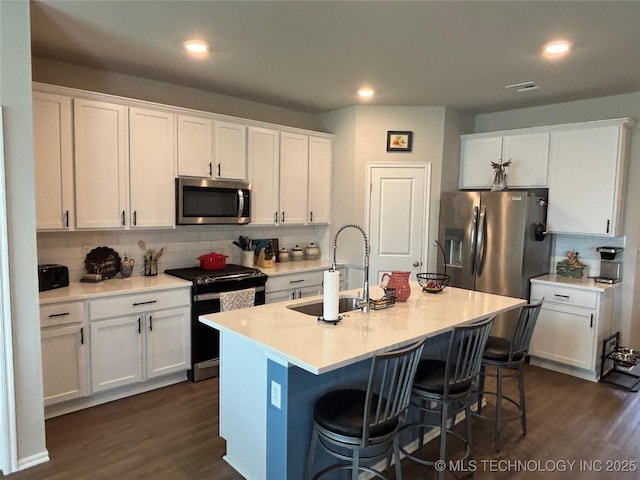 4242 W Village Park Dr, Skiatook, OK 74070 - kitchen with a sink, decorative backsplash, dark wood-style floors, and appliances with stainless steel finishes