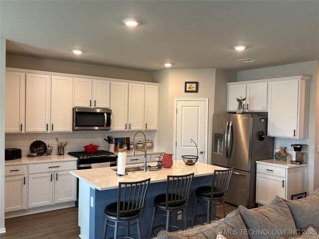 4242 W Village Park Dr, Skiatook, OK 74070 - kitchen featuring stainless steel appliances, tasteful backsplash, a kitchen breakfast bar, and white cabinets