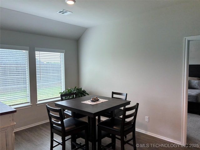 4242 W Village Park Dr, Skiatook, OK 74070 - dining space featuring baseboards, vaulted ceiling, visible vents, and dark wood-type flooring
