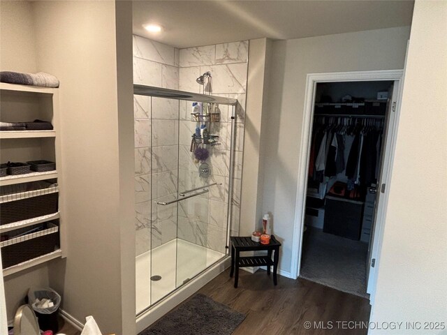 4242 W Village Park Dr, Skiatook, OK 74070 - bathroom with a stall shower, a spacious closet, baseboards, and wood finished floors