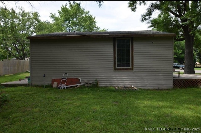 view of home's exterior with fence and a lawn