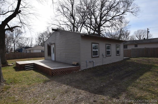 exterior space featuring a lawn, a deck, and fence