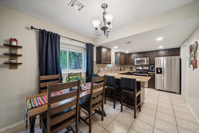 dining area featuring a chandelier, light tile patterned flooring, recessed lighting, and baseboards