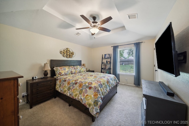 bedroom featuring light colored carpet, a ceiling fan, a raised ceiling, and baseboards