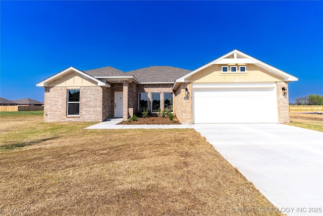 view of front facade with concrete driveway, a front lawn, brick siding, and an attached garage