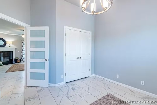 6442 E 148th St S, Bixby, OK 74008 - interior space featuring a glass covered fireplace, a notable chandelier, baseboards, and marble finish floor