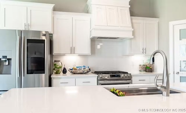 6442 E 148th St S, Bixby, OK 74008 - kitchen featuring a sink, stainless steel appliances, white cabinetry, light countertops, and custom range hood