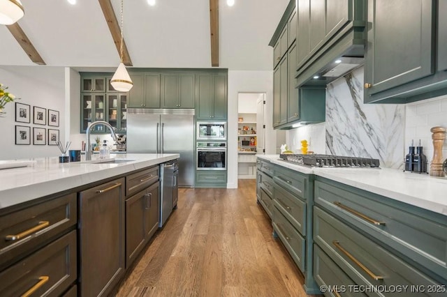 16804 E 43rd St S, Tulsa, OK 74134 - kitchen with a sink, wood finished floors, green cabinetry, tasteful backsplash, and appliances with stainless steel finishes
