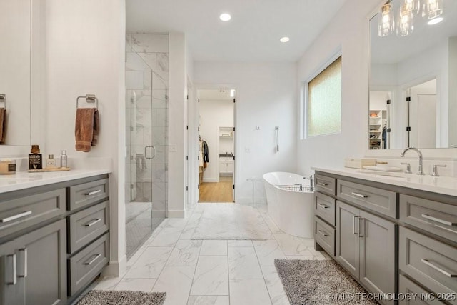 16804 E 43rd St S, Tulsa, OK 74134 - bathroom with a stall shower, a sink, a freestanding bath, marble finish floor, and recessed lighting