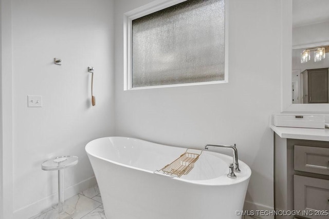 16804 E 43rd St S, Tulsa, OK 74134 - full bath featuring marble finish floor, vanity, a wealth of natural light, a freestanding bath, and baseboards