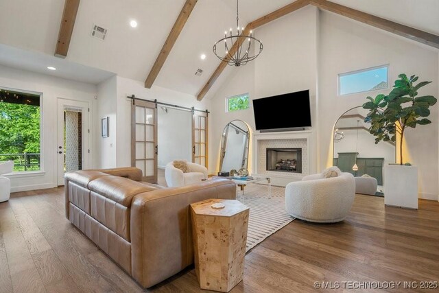 16804 E 43rd St S, Tulsa, OK 74134 - living area with a barn door, visible vents, high vaulted ceiling, wood finished floors, and beam ceiling