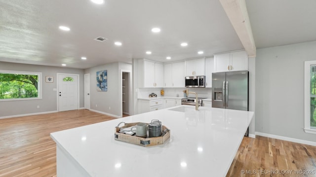 4010 E Harris, Muskogee, OK 74403 - kitchen featuring light wood-type flooring, appliances with stainless steel finishes, visible vents, and white cabinetry