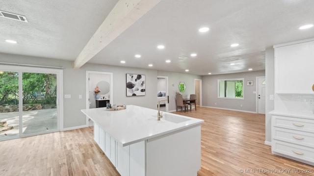 4010 E Harris, Muskogee, OK 74403 - kitchen featuring light wood finished floors, a sink, white cabinets, visible vents, and baseboards