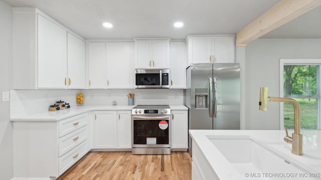 4010 E Harris, Muskogee, OK 74403 - kitchen featuring light wood-style flooring, a sink, white cabinetry, light countertops, and appliances with stainless steel finishes