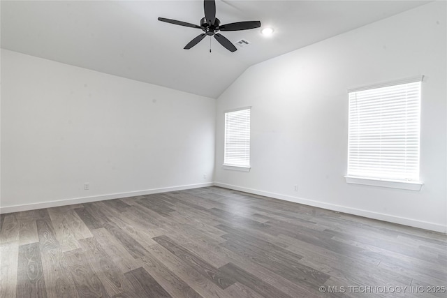 empty room featuring lofted ceiling, baseboards, ceiling fan, visible vents, and wood finished floors