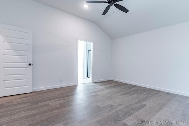 unfurnished room with lofted ceiling, baseboards, a ceiling fan, and wood finished floors