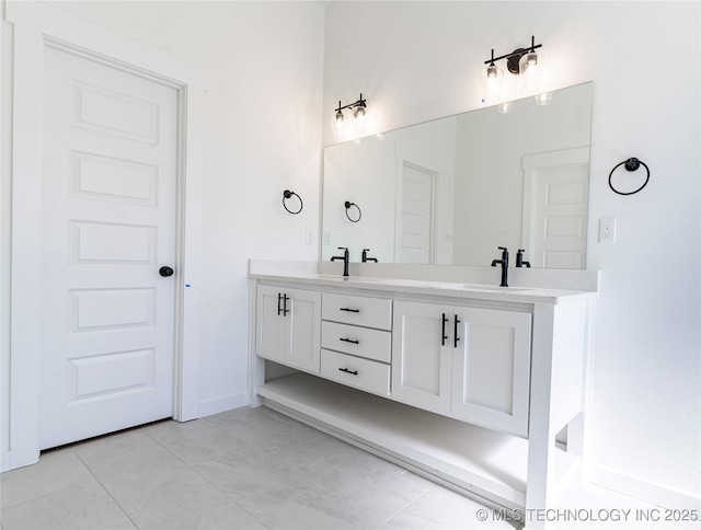 full bathroom with a sink, double vanity, and baseboards