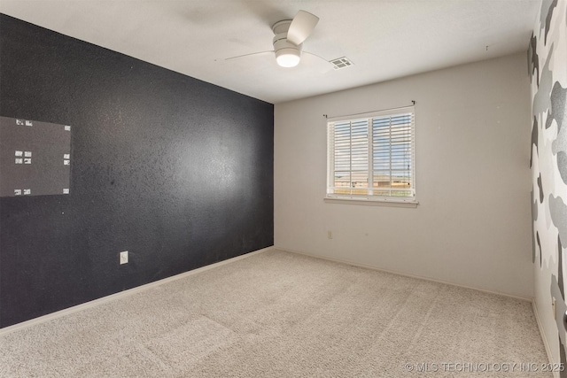unfurnished room featuring carpet flooring, visible vents, baseboards, and ceiling fan