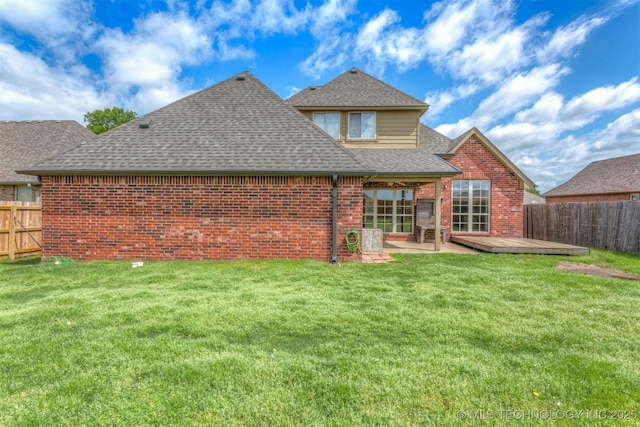 rear view of house featuring a fenced backyard, a shingled roof, brick siding, and a lawn