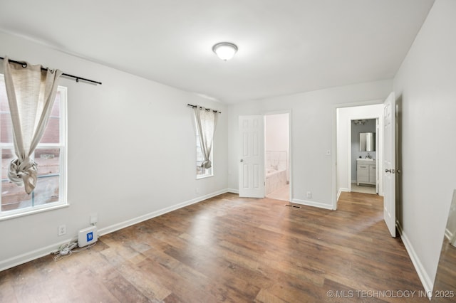 1109 S Division St, Sapulpa, OK 74066 - unfurnished bedroom featuring connected bathroom, visible vents, wood finished floors, and baseboards