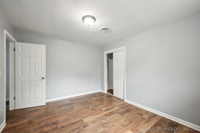 1109 S Division St, Sapulpa, OK 74066 - unfurnished bedroom with a closet, baseboards, visible vents, and wood finished floors
