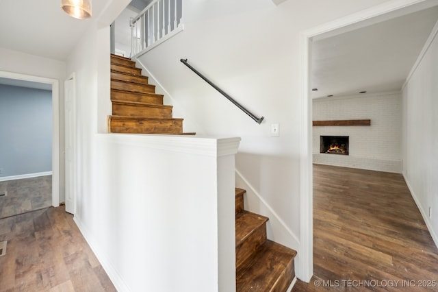 1109 S Division St, Sapulpa, OK 74066 - stairway featuring a brick fireplace, baseboards, and wood finished floors
