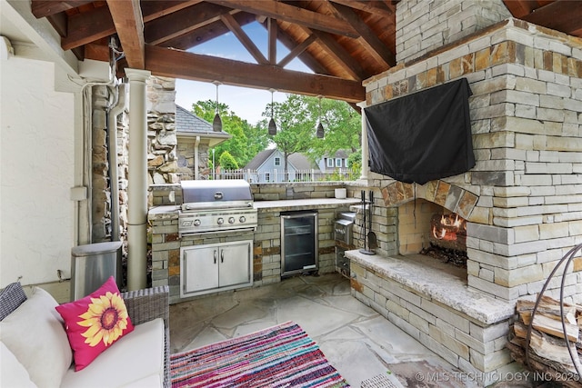 view of patio / terrace featuring an outdoor stone fireplace, a grill, area for grilling, and a gazebo