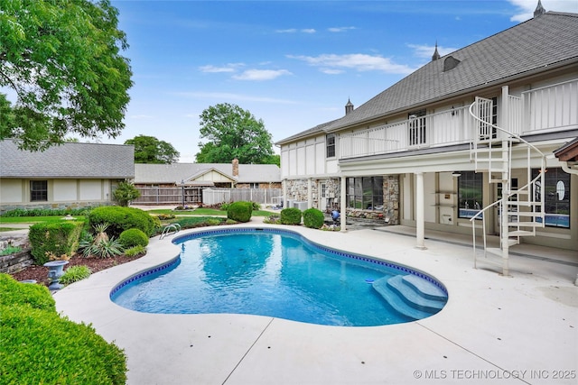 view of swimming pool featuring a patio area and fence