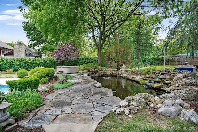 view of yard with a small pond and fence
