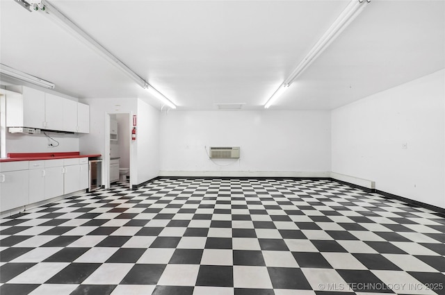 basement featuring tile patterned floors, baseboards, and wine cooler