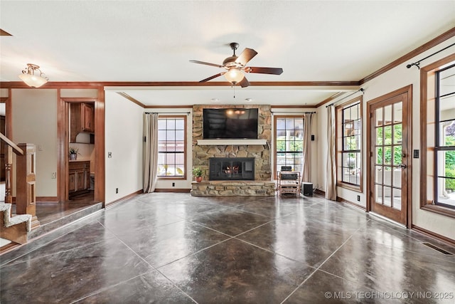 unfurnished living room with crown molding, a fireplace, baseboards, stairs, and a ceiling fan