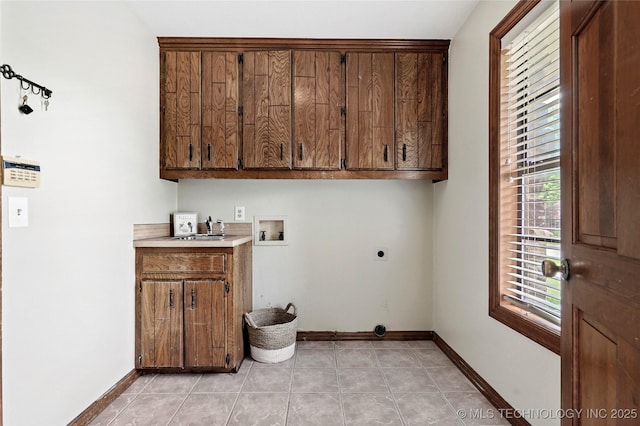 clothes washing area with cabinet space, hookup for a washing machine, electric dryer hookup, baseboards, and plenty of natural light