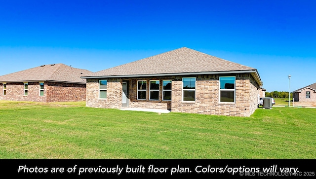 rear view of property with a yard, central air condition unit, roof with shingles, and brick siding