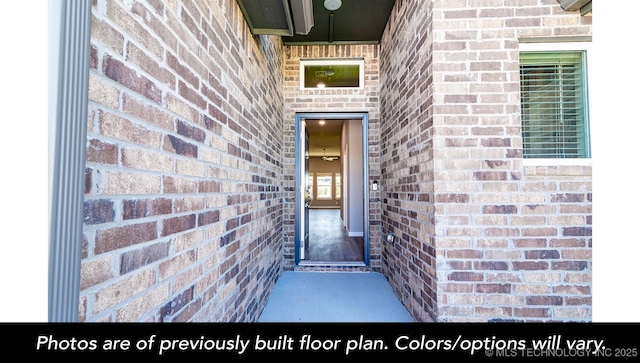 view of exterior entry featuring brick siding