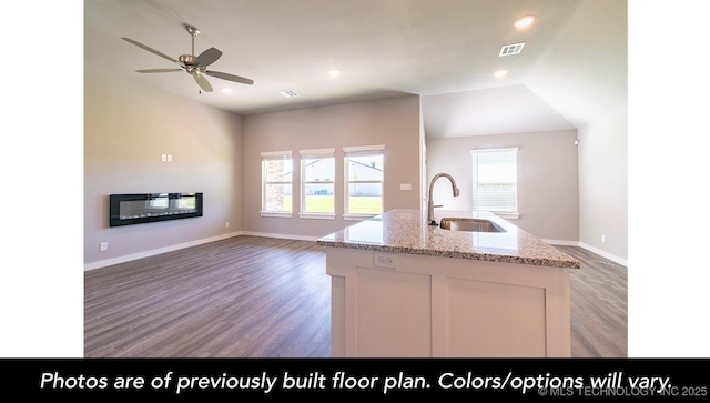 kitchen featuring a sink, open floor plan, visible vents, ceiling fan, and light wood-style floors