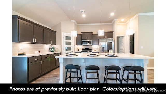 1421 E 150th Pl S, Glenpool, OK 74033 - kitchen featuring a breakfast bar, stainless steel appliances, tasteful backsplash, and light countertops