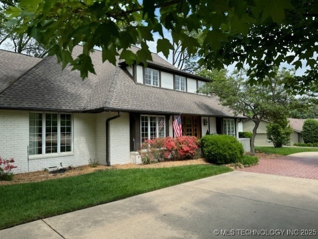 3421 E 62nd St, Tulsa, OK 74136 - view of front of home with roof with shingles, brick siding, and a front lawn