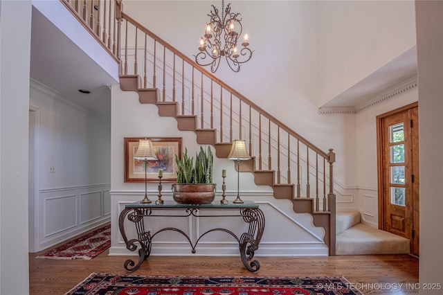 3421 E 62nd St, Tulsa, OK 74136 - stairway featuring wood finished floors, a decorative wall, ornamental molding, a chandelier, and a wainscoted wall