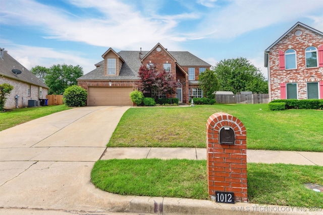 traditional home with fence, an attached garage, brick siding, concrete driveway, and a front lawn