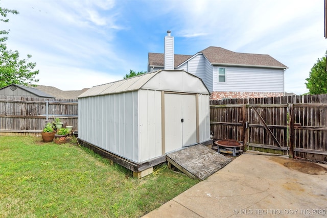 view of shed featuring a fenced backyard and a gate