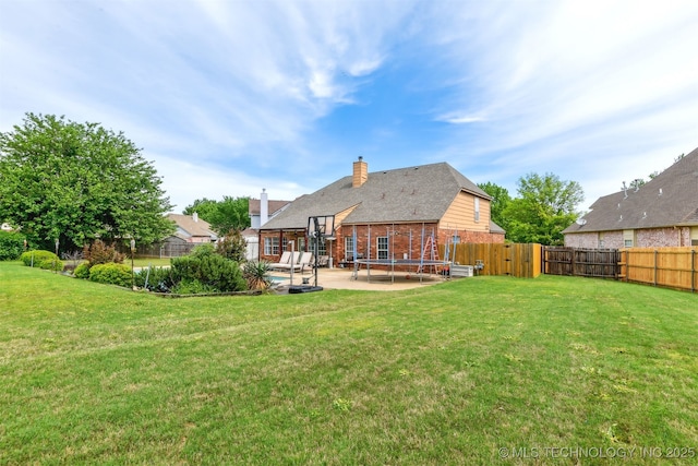 rear view of house featuring a fenced backyard, a patio area, brick siding, and a lawn