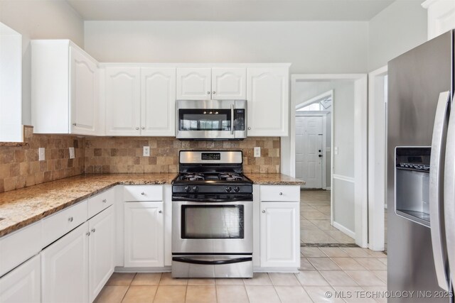 kitchen with light stone countertops, appliances with stainless steel finishes, and decorative backsplash